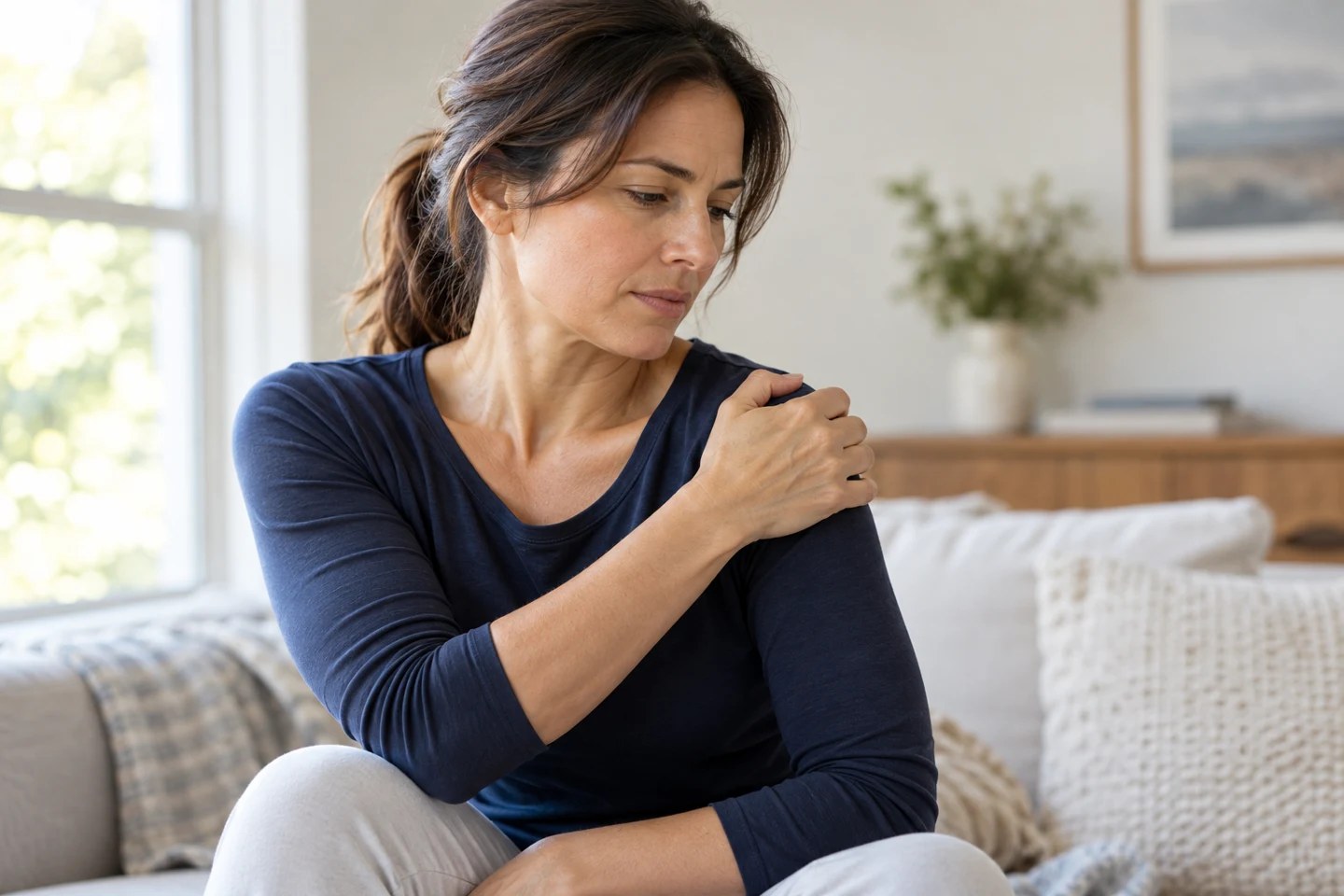 Woman holding her painful shoulder